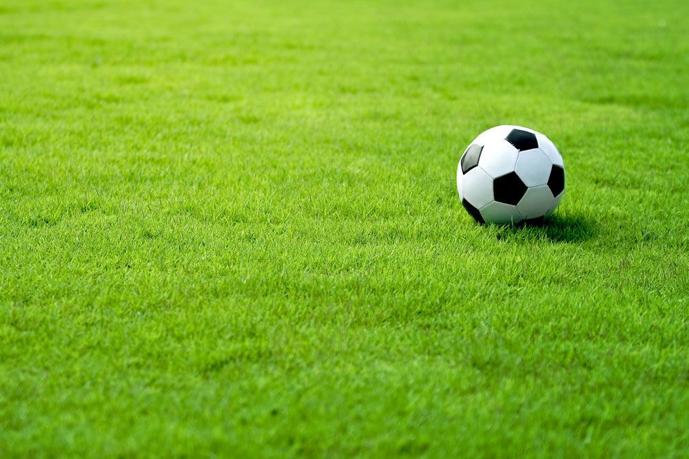 Fußballspielen auf grünem Rasen