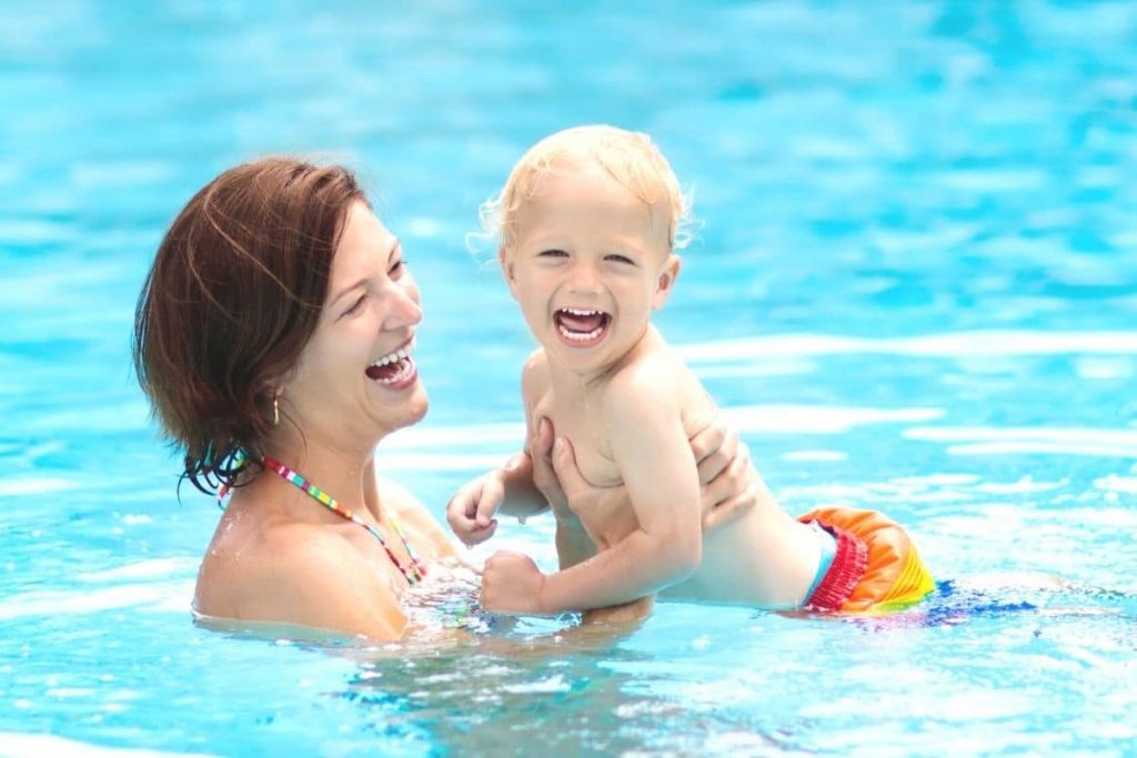 Mutter planscht mit Kind im Pool