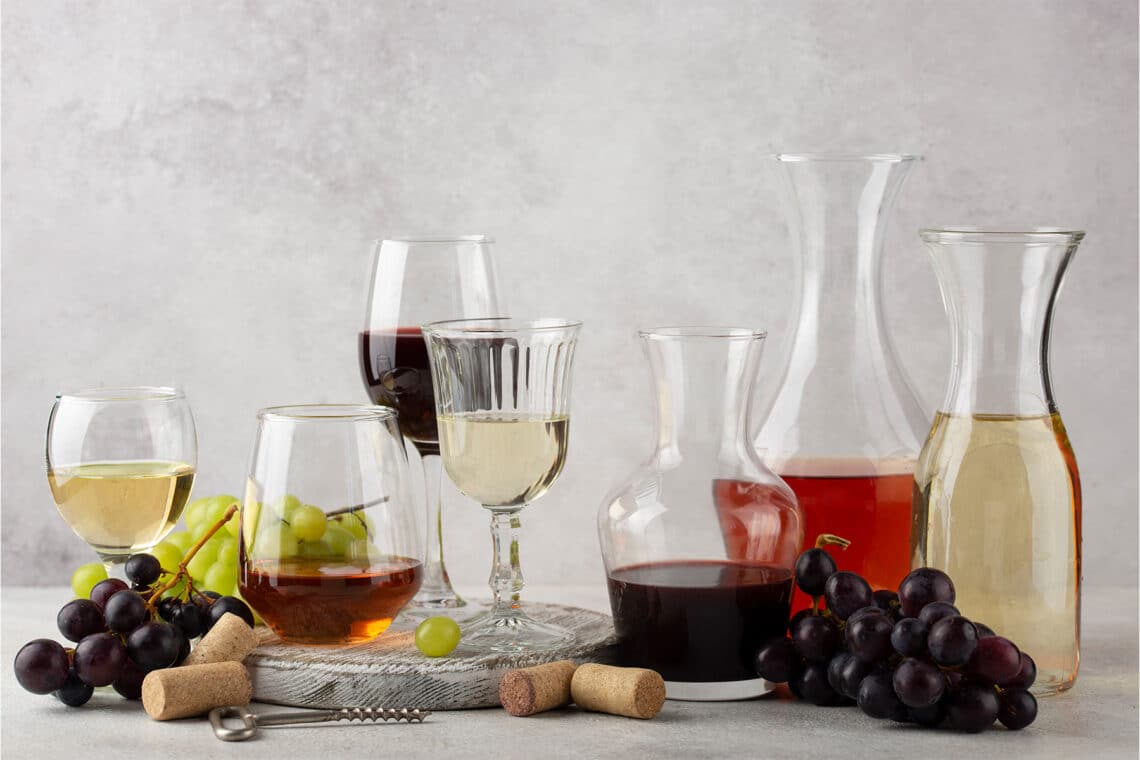 verschiedene Weine aus Weintrauben in Gläsern und Karaffen