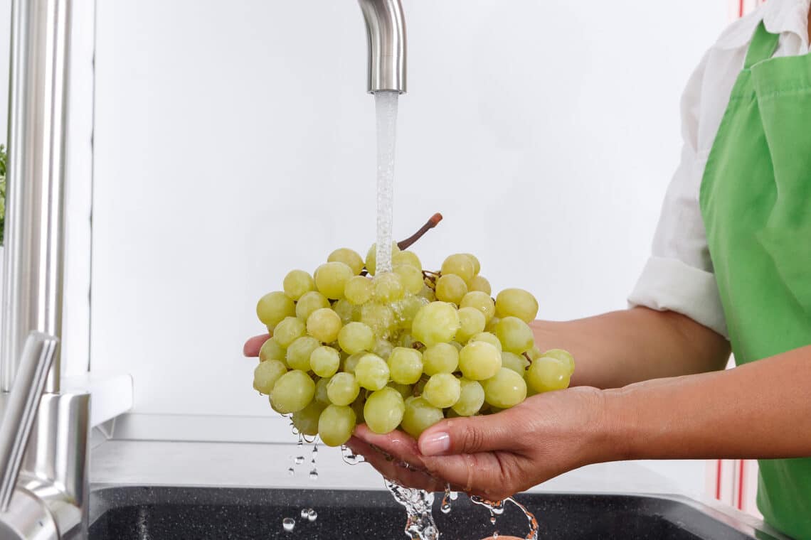 Weintrauben waschen unter dem Wasserhahn